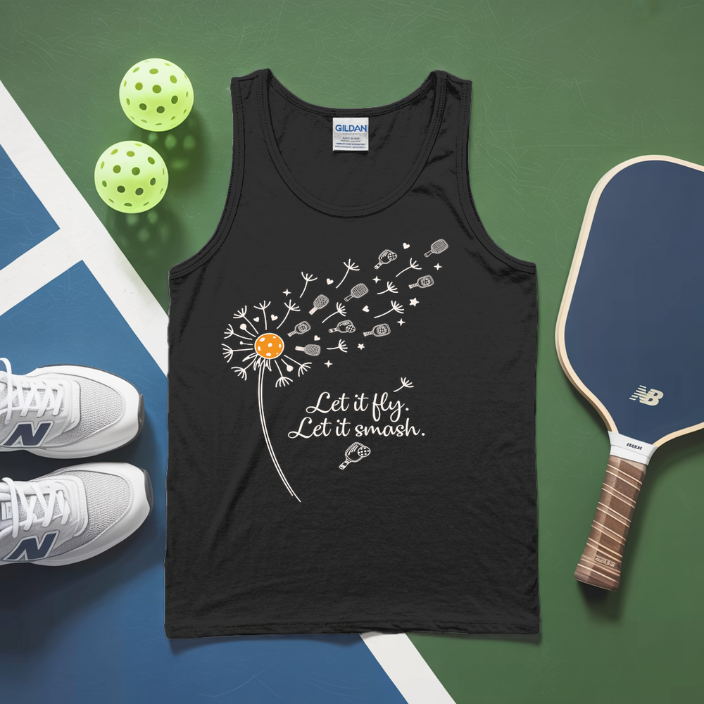 White tank top with dandelion design and text, placed on a green and blue surface with pickleballs and a paddle.
