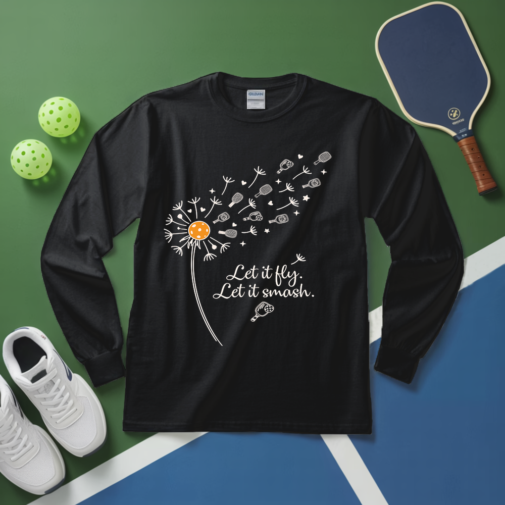 Black long-sleeve shirt with a dandelion graphic and text on a green and blue surface with sports equipment.