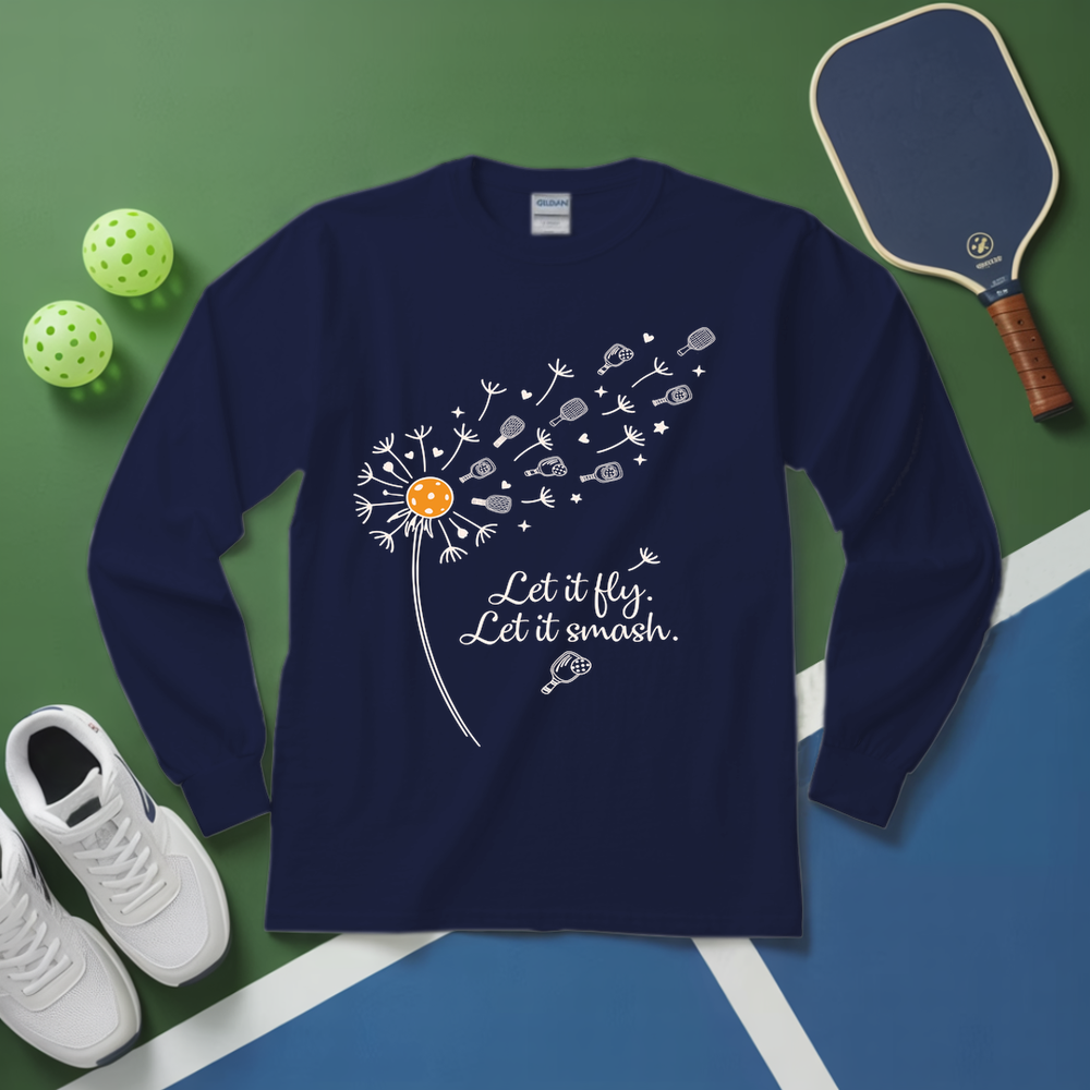 Navy blue long-sleeve shirt with dandelion graphic and text on a green and blue surface with pickleballs and a paddle.