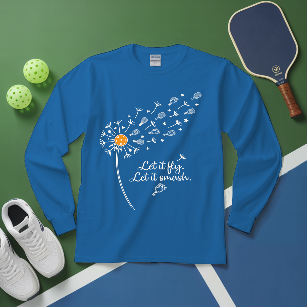 Blue long-sleeve shirt with dandelion graphic and text on a green and blue surface with sports equipment.