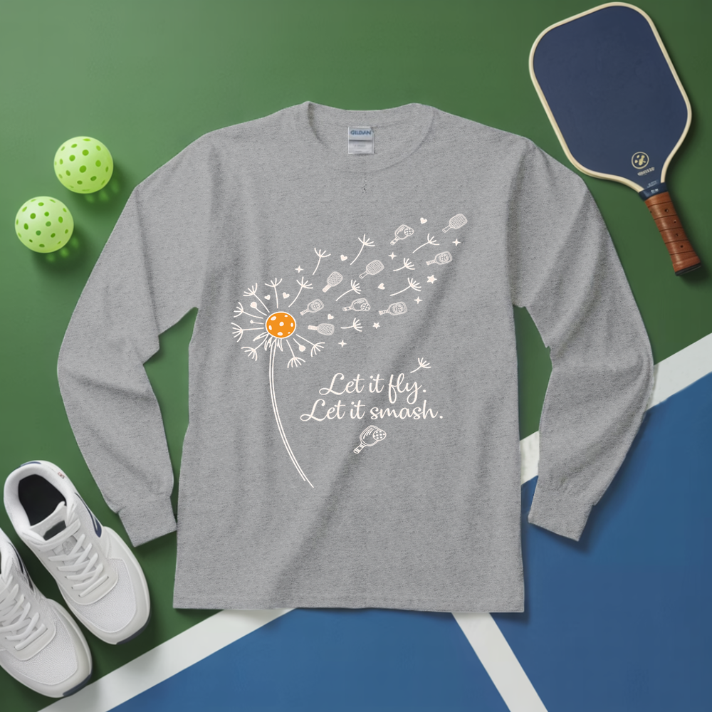 Gray long-sleeve shirt with a dandelion graphic and text, placed on a green and blue surface with sports equipment.