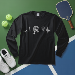 Black long-sleeve shirt with pickleball design on a green and blue surface with pickleball equipment.