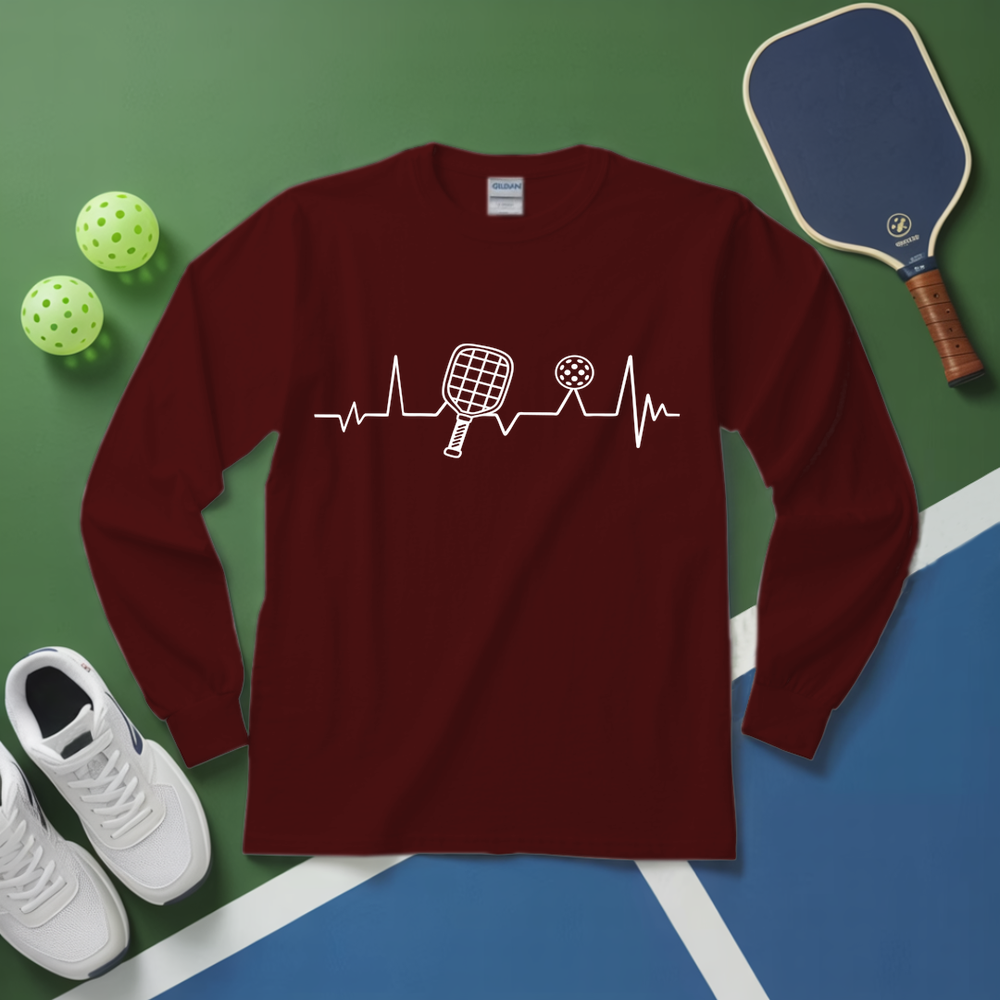 Maroon long-sleeve shirt with pickleball design on a green and blue surface with pickleball equipment.
