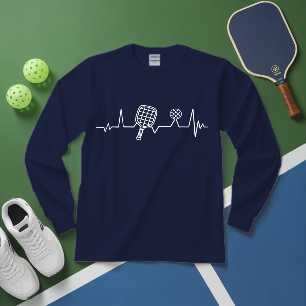 Navy blue long-sleeve shirt with pickleball design on a green and blue surface with pickleballs and paddle.