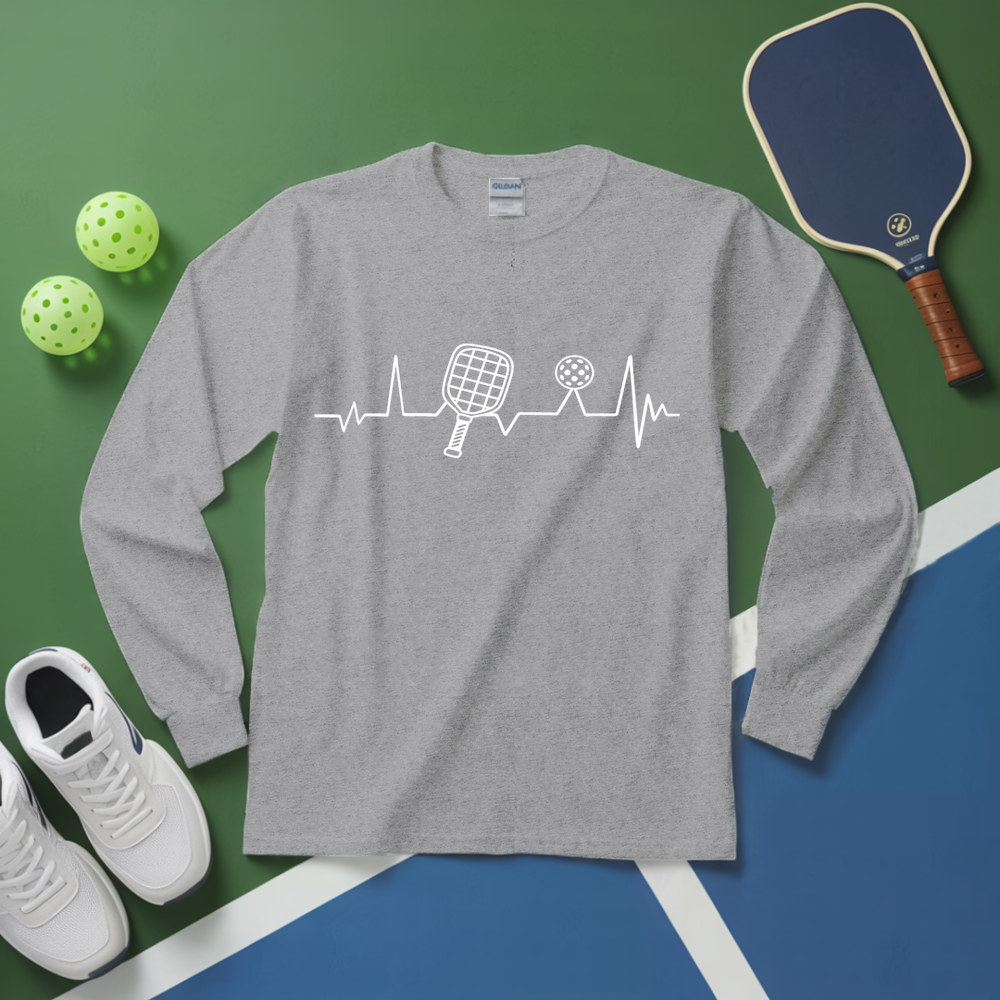 Gray long-sleeve shirt with pickleball design on a green and blue surface with pickleball equipment.