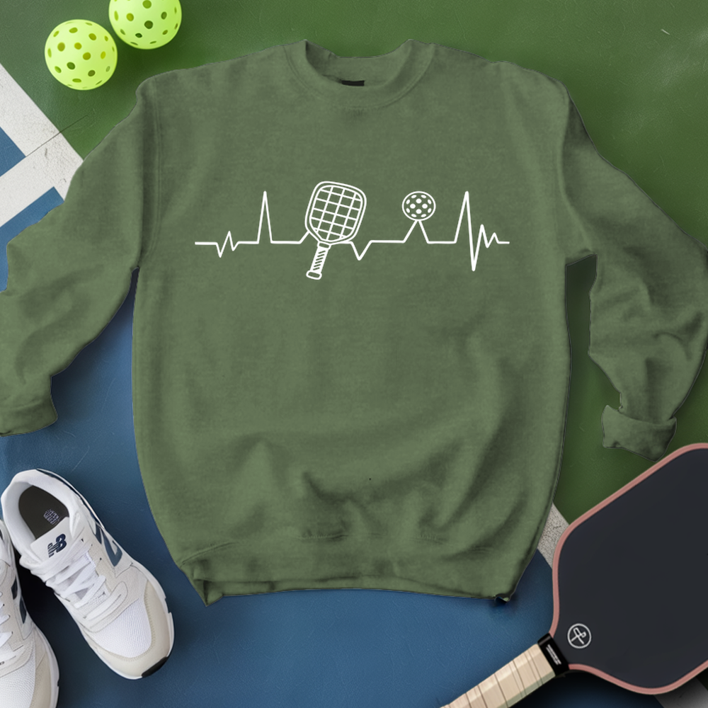 Green sweatshirt with pickleball design, shoes, and paddle on a green and blue background