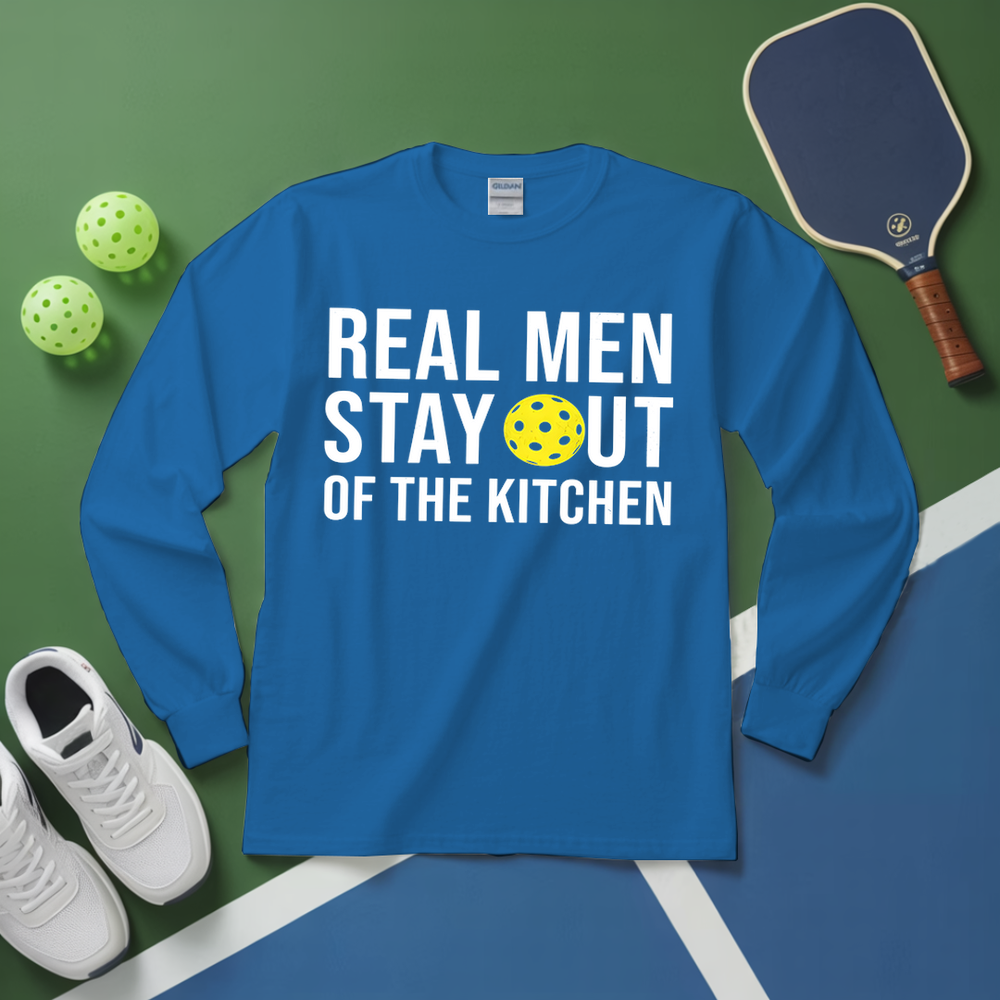Blue long-sleeve shirt with text and pickleball equipment on a green and blue surface