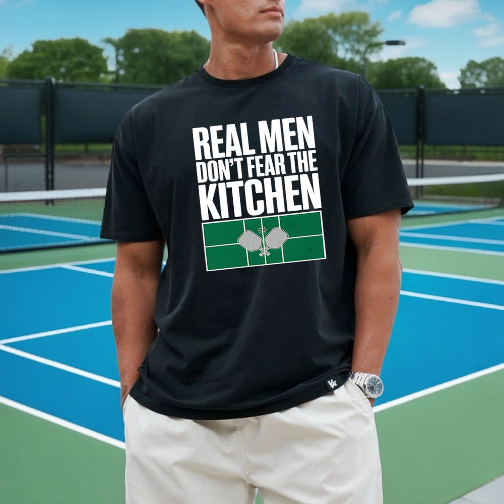 Person wearing a black t-shirt with a humorous kitchen-themed design on a tennis court.