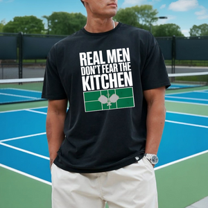 Person wearing a black t-shirt with a humorous kitchen-themed design on a tennis court.