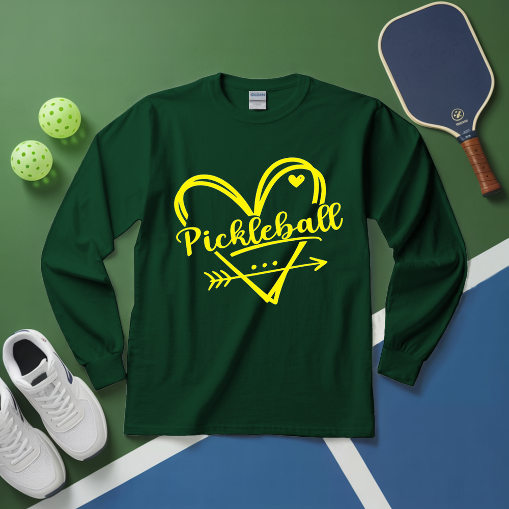 Green long-sleeve shirt with yellow 'Pickleball' design on a green and blue surface with pickleball equipment.