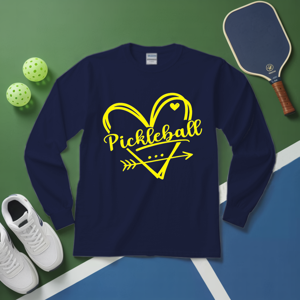 Navy long-sleeve shirt with yellow 'Pickleball' design on a green and blue surface with pickleball equipment.
