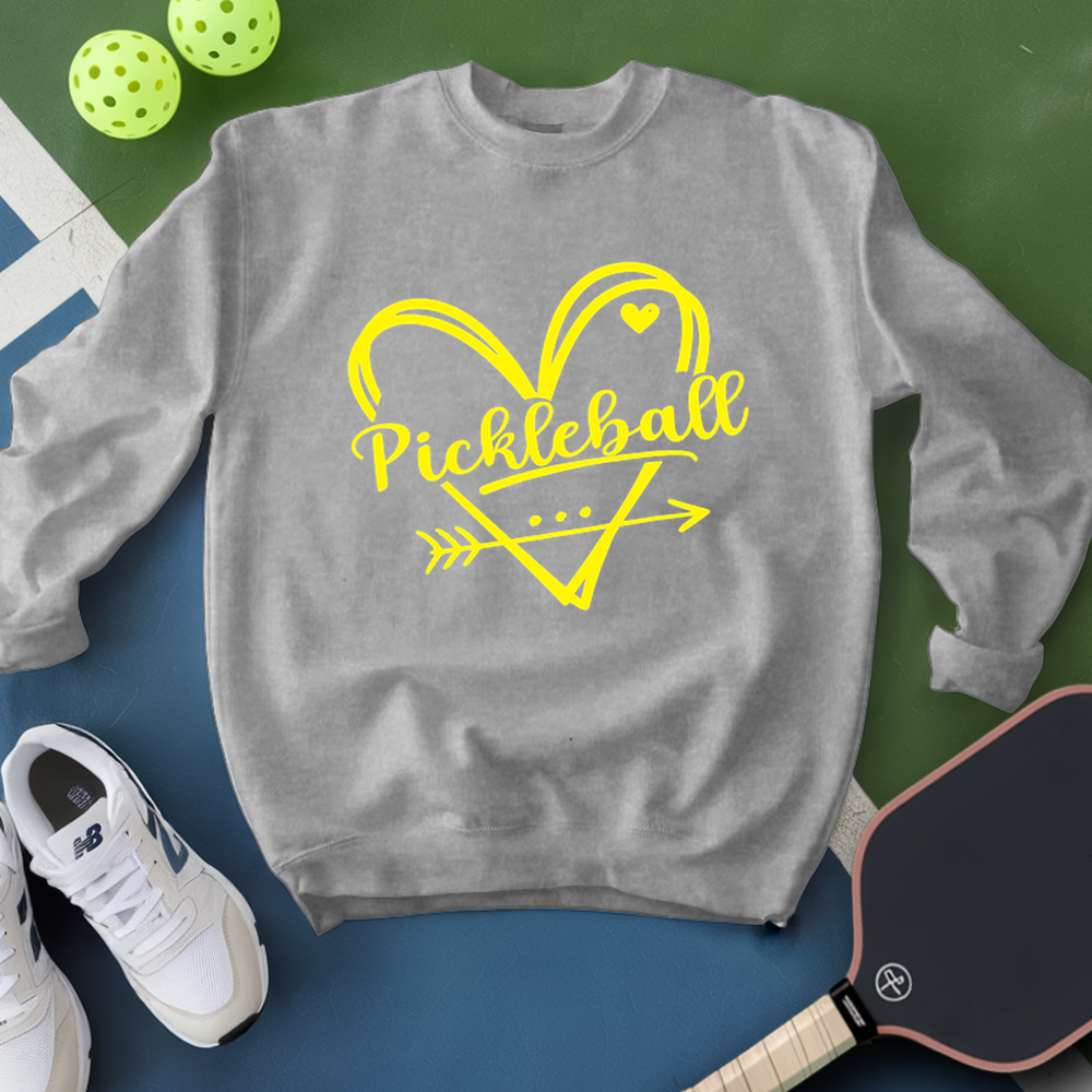 Gray sweatshirt with yellow 'Pickleball' design on a green and blue background with pickleball equipment.