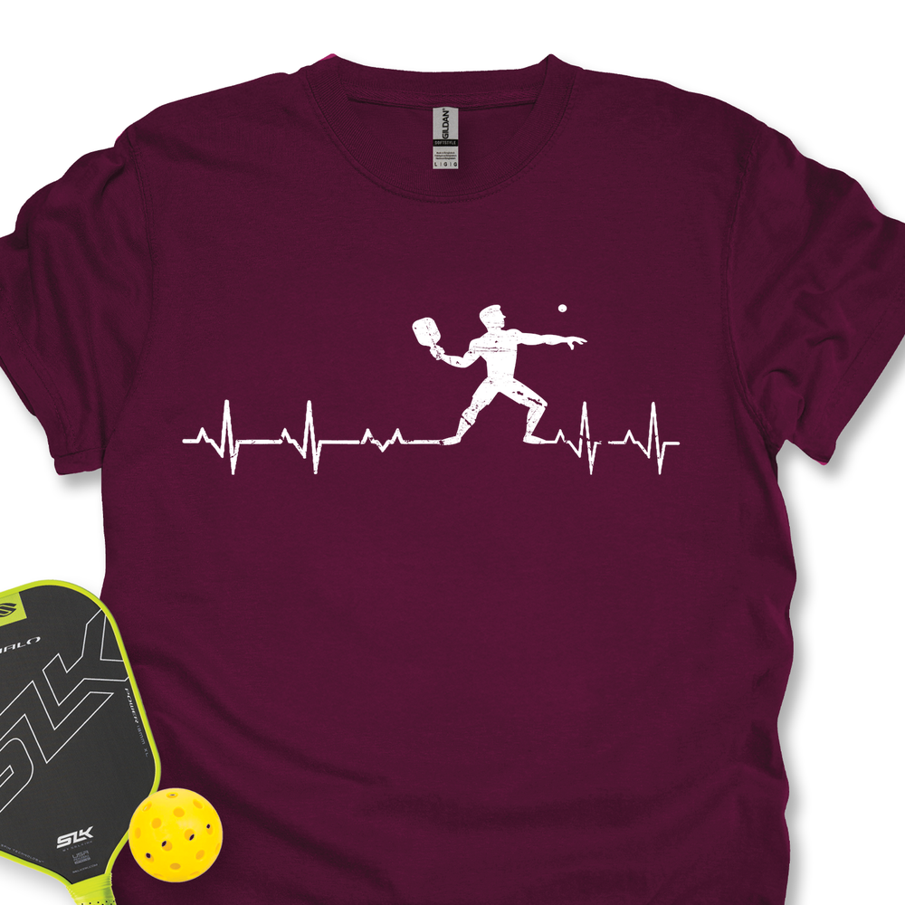Maroon t-shirt with pickleball design and paddle and ball on a white background