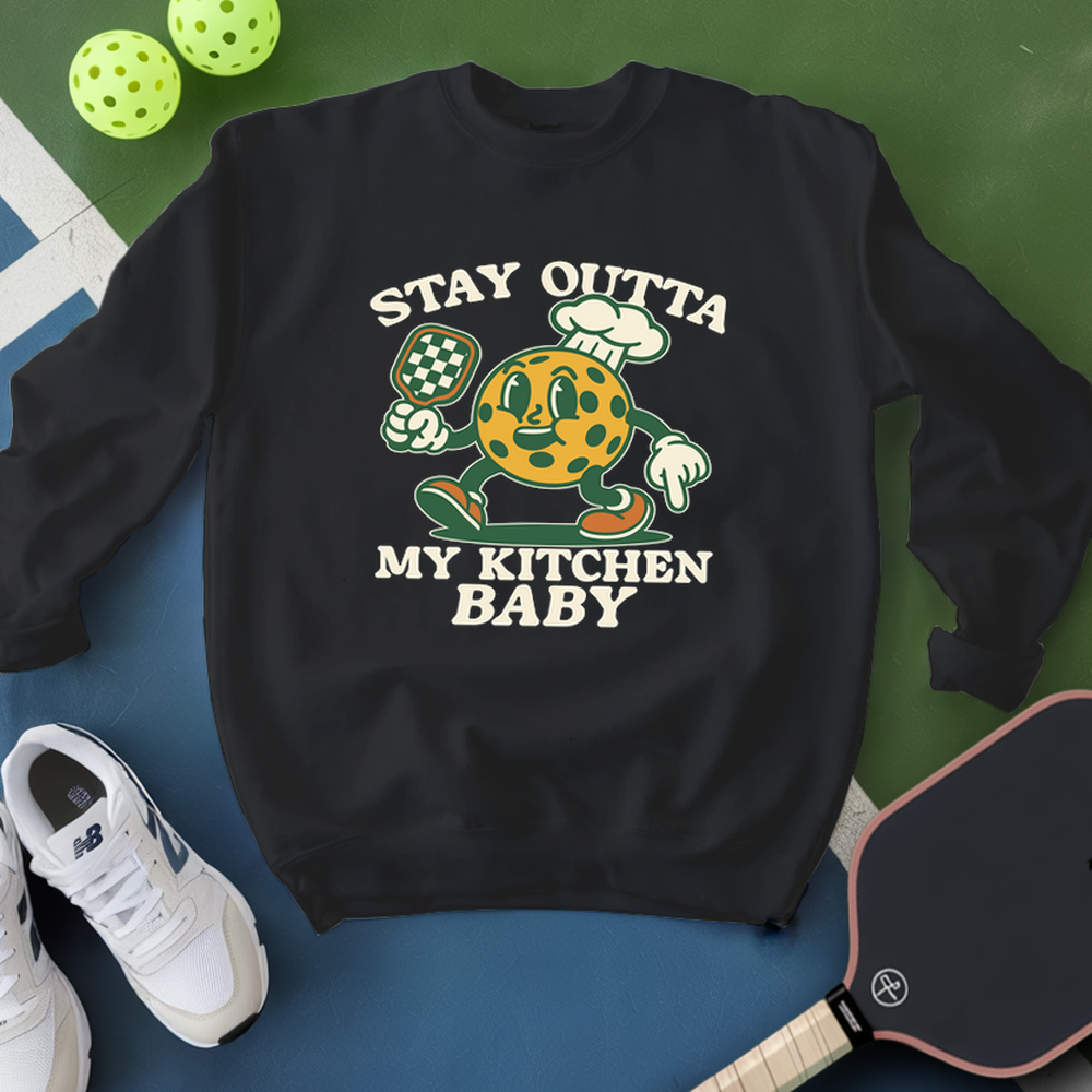 Black sweatshirt with a graphic design and text, placed on a green and blue surface with sports equipment.