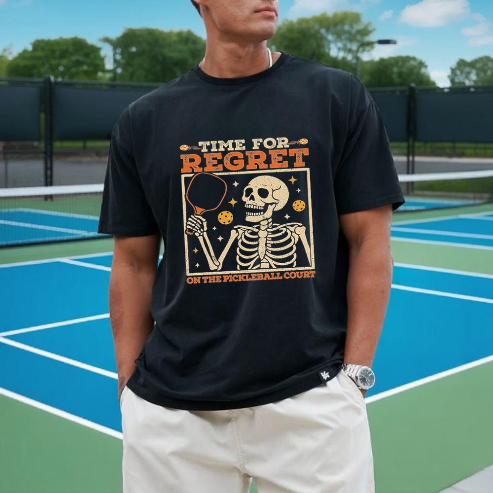 Person wearing a black t-shirt with a graphic design on a pickleball court
