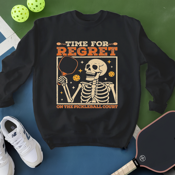 Black sweatshirt with skeleton design and text on a blue and green background with pickleball equipment.