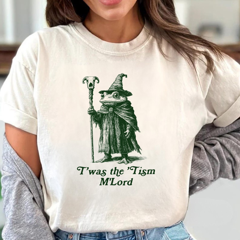 Person wearing a white t-shirt with a graphic of a wizard and text, standing indoors.