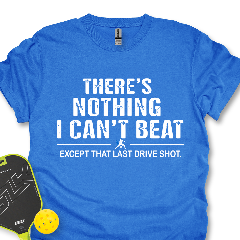 Blue t-shirt with white text 'There's nothing I can't beat except that last drive shot' on a white background.