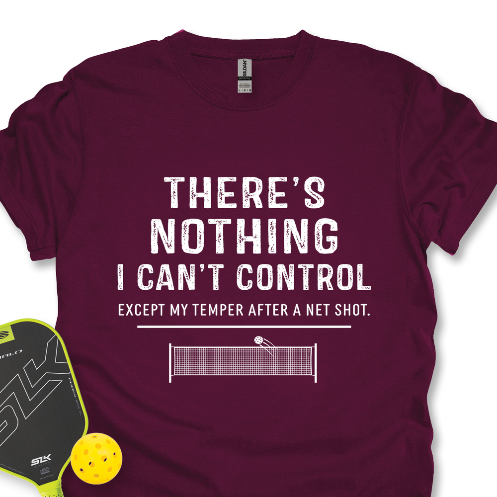 Maroon t-shirt with humorous text design, pickleball paddle, and ball on a white background