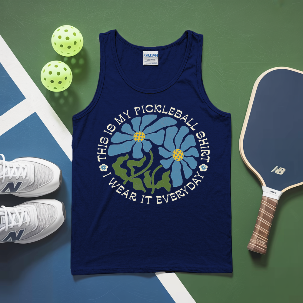 Navy tank top with pickleball design on a green and blue surface with pickleballs and a paddle.
