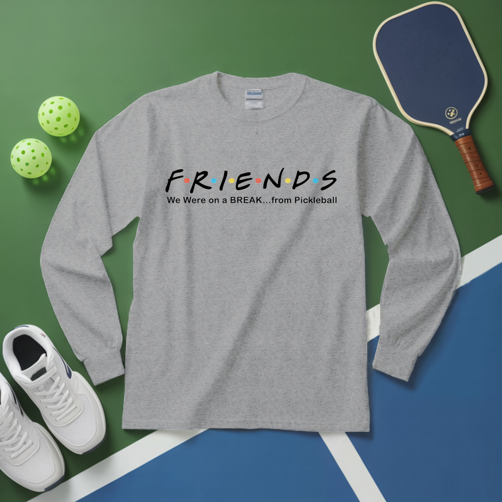 Gray long-sleeve shirt with 'FRIENDS' design on a green and blue surface with pickleball equipment.