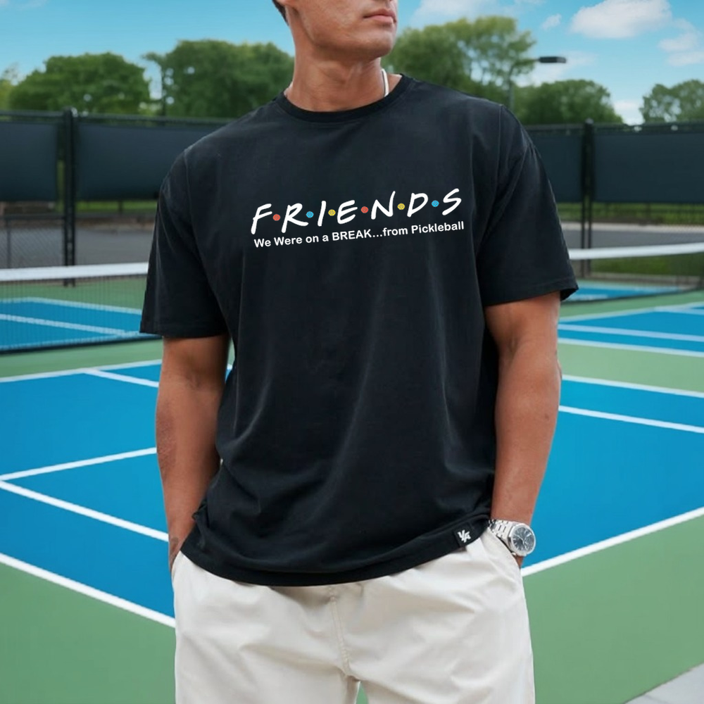 Person wearing a black t-shirt with 'FRIENDS' text on a pickleball court