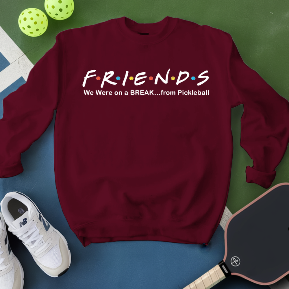 Maroon sweatshirt with 'FRIENDS' design, pickleball paddle, and balls on a green and blue background