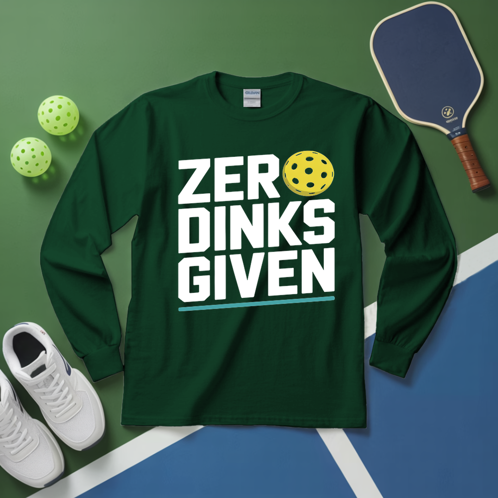 Green long-sleeve shirt with 'ZERO DINKS GIVEN' text, pickleball paddle, balls, and shoes on a green and blue surface.