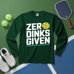 Green long-sleeve shirt with 'ZERO DINKS GIVEN' text, pickleball paddle, balls, and shoes on a green and blue surface.