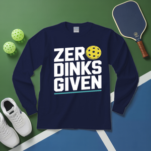 Navy blue sweatshirt with 'ZERO DINKS GIVEN' text, pickleball paddle, balls, and shoes on a green and blue surface.
