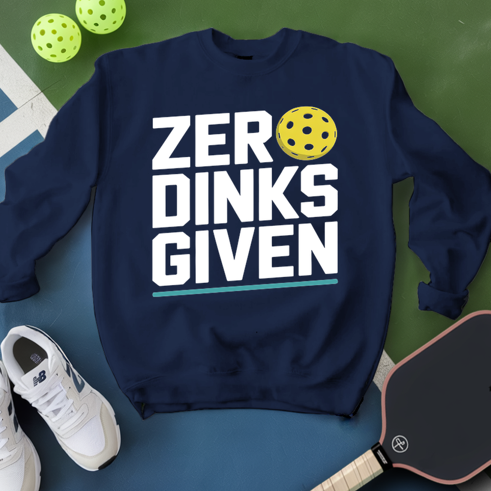 Navy sweatshirt with 'ZER DINKS GIVEN' text and pickleball ball, surrounded by pickleballs and a paddle on a green and blue background.