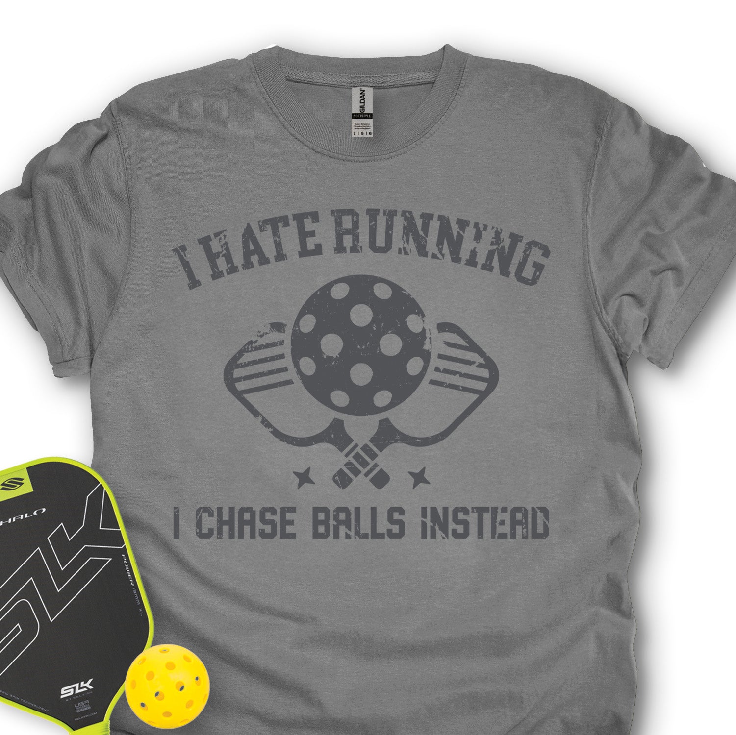 Gray t-shirt with pickleball-themed design and accessories on a white background