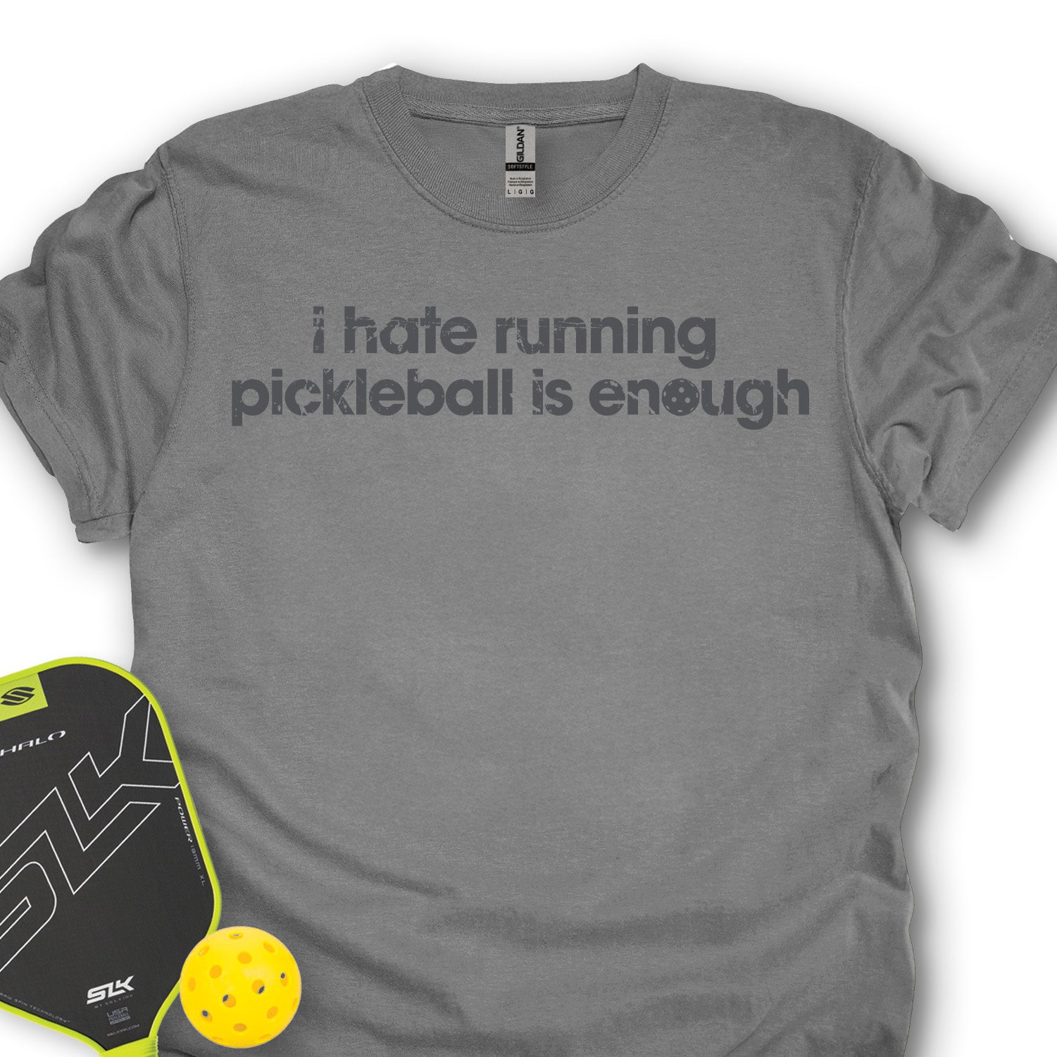 Gray t-shirt with text 'i hate running pickleball is enough' and a pickleball paddle and ball on a white background