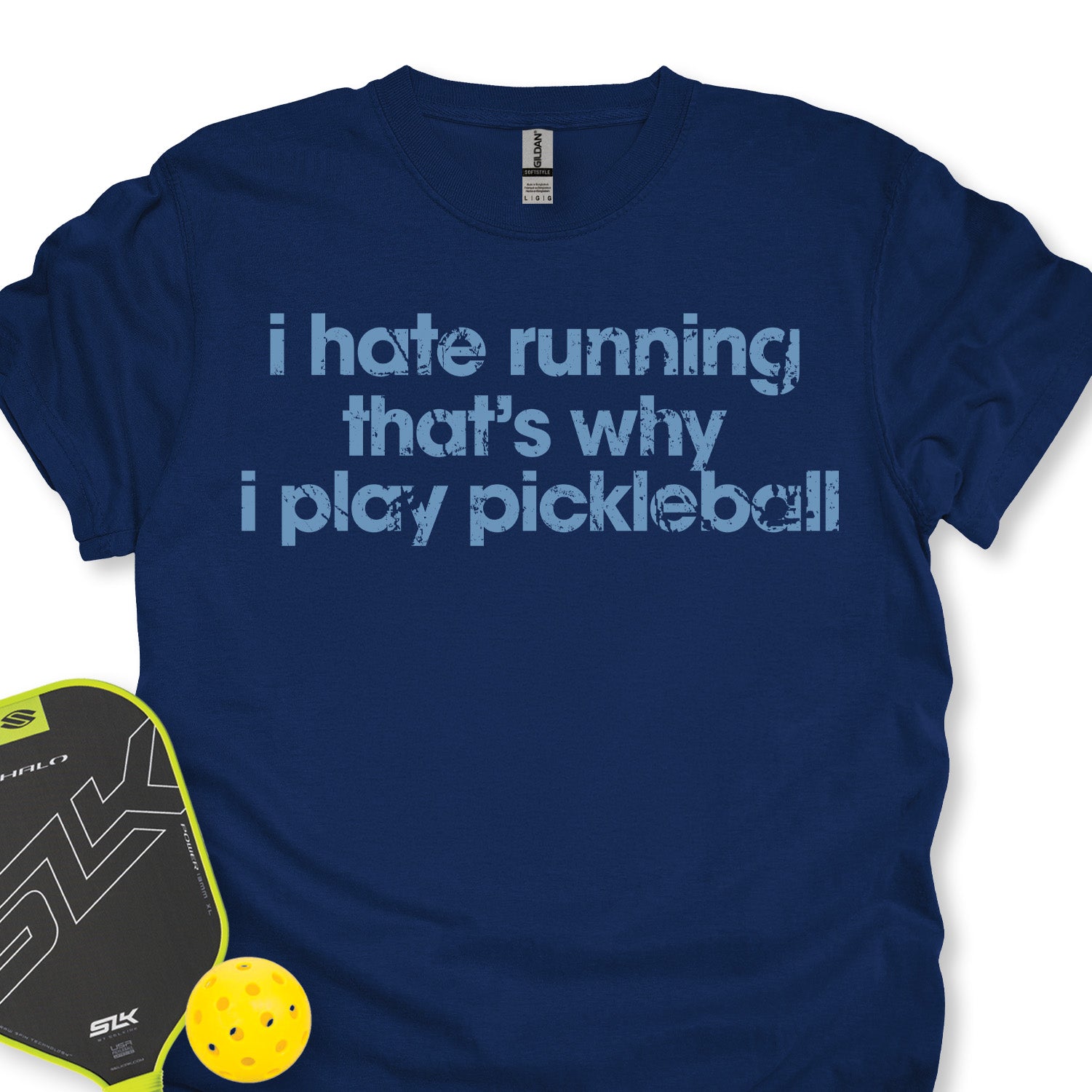 Blue t-shirt with humorous pickleball text, pickleball paddle, and ball on a white background