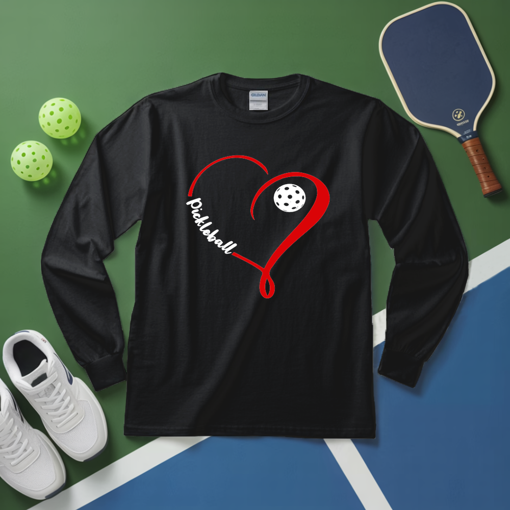 Black long-sleeve shirt with pickleball design on a green and blue surface with pickleballs and a paddle.