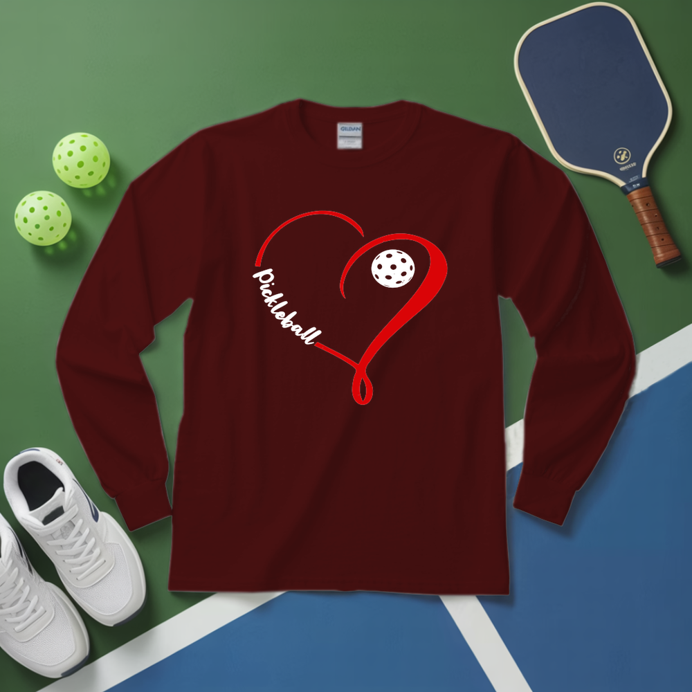 Maroon long-sleeve shirt with pickleball design on a green and blue surface with pickleballs and a paddle.
