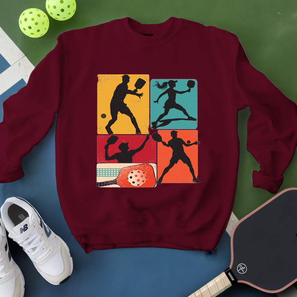 Maroon sweatshirt with pickleball design on a blue and green background
