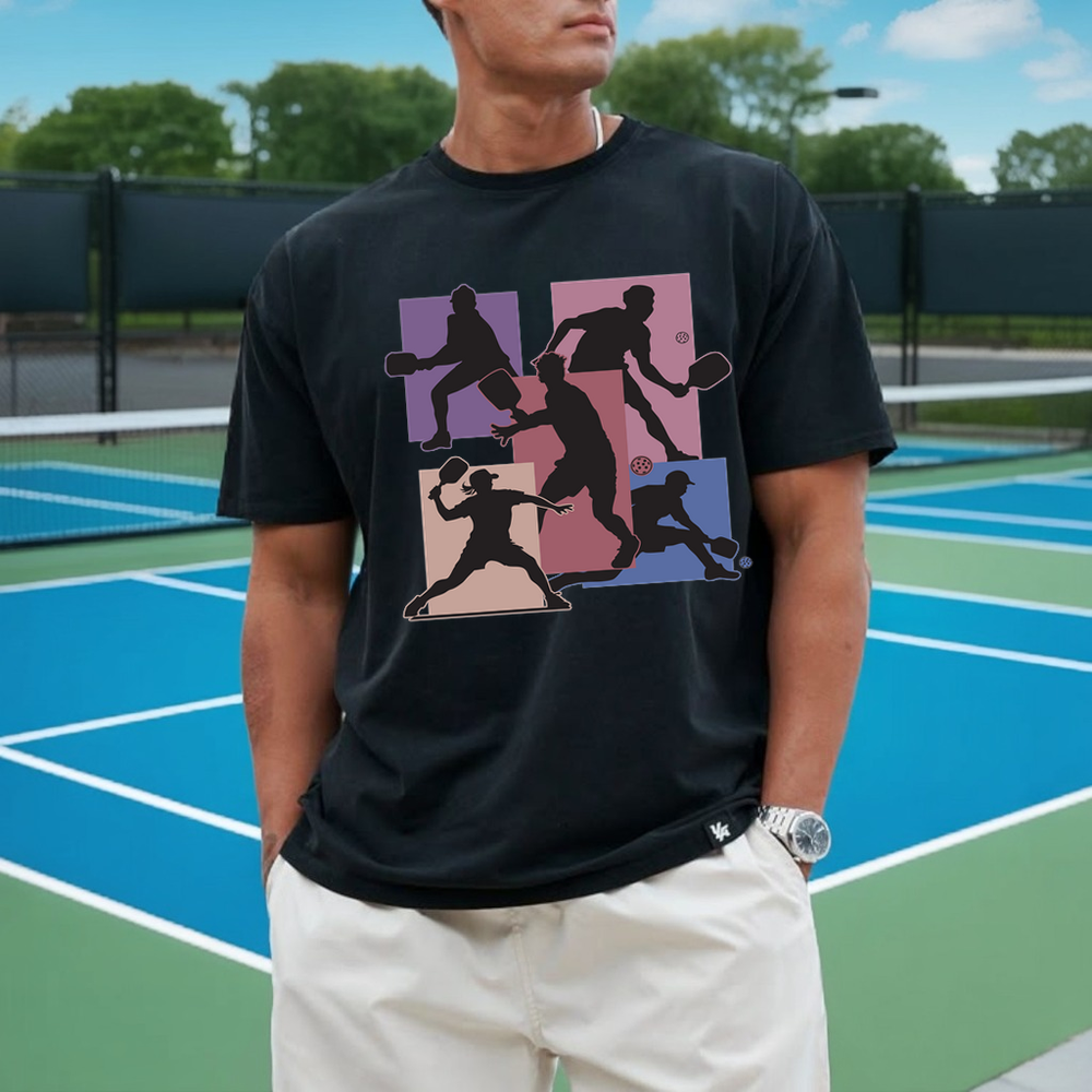 Person wearing a black t-shirt with colorful graphic design on a tennis court
