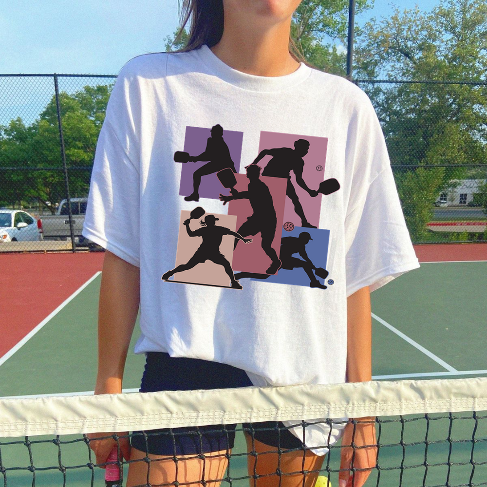 Person wearing a white t-shirt with black graphic design on a tennis court