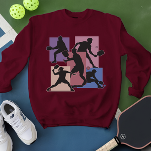 Maroon sweatshirt with pickleball player design on a blue and green background
