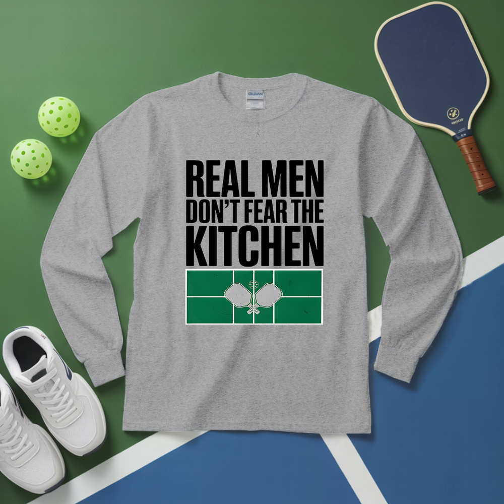 Gray long-sleeve shirt with 'Real men don't fear the kitchen' text and pickleball equipment on a green and blue background